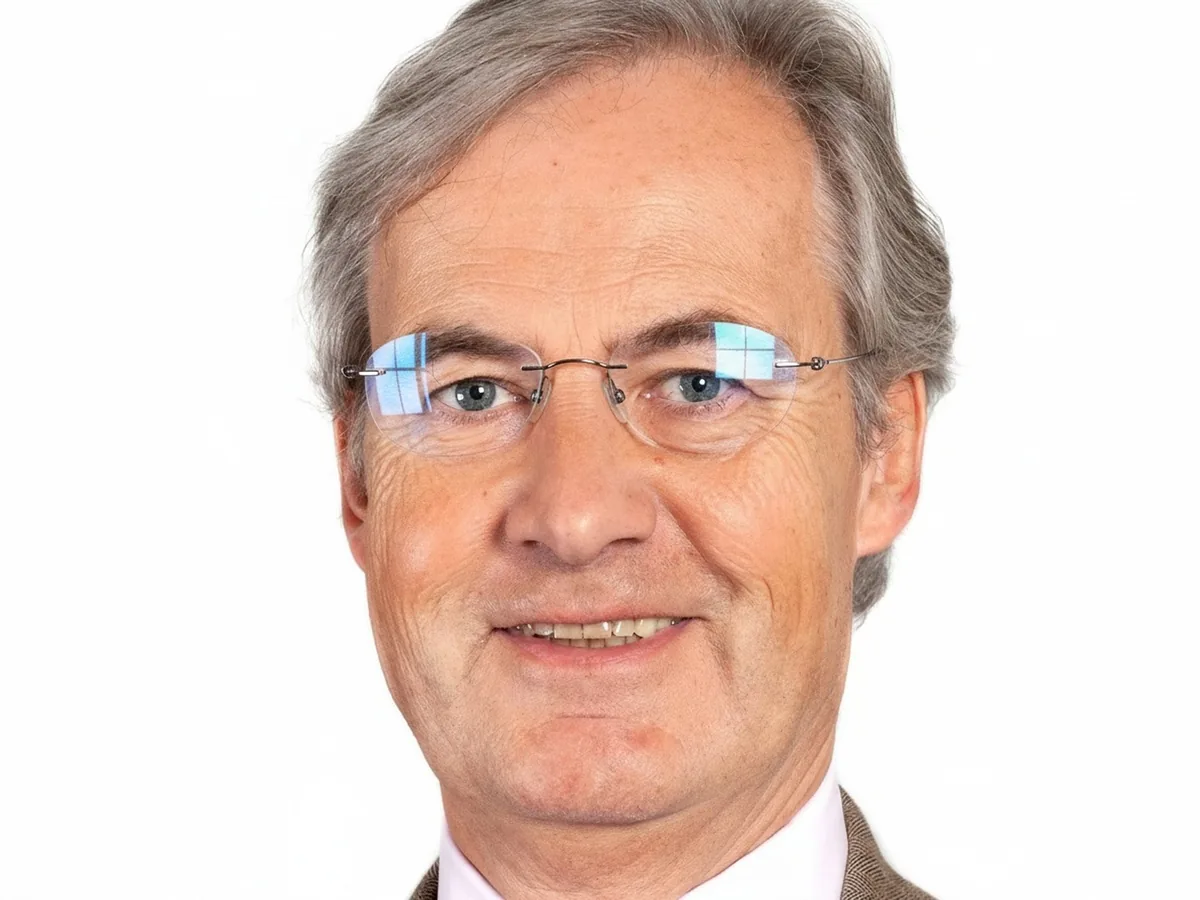 Man with window reflections on his rimless glasses, before enhancement