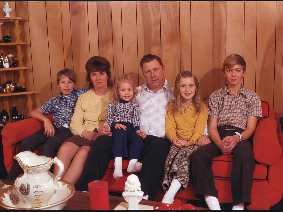 Faded 1970s family photo on a red sofa